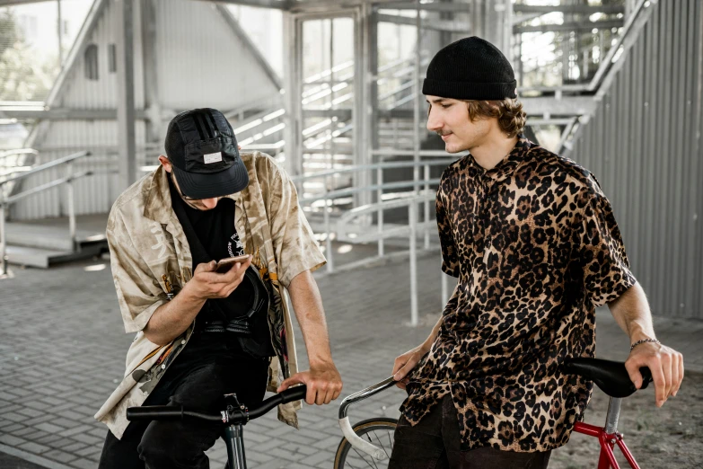 a couple of men riding bikes next to each other, a portrait, trending on pexels, wearing animal skin clothing, streetwear, looking at his phone, beksinsky