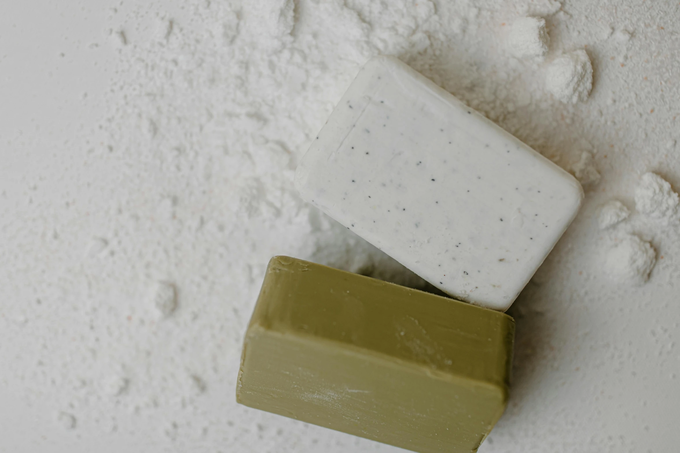 a couple of soap bars sitting on top of a pile of white powder, inspired by Rachel Whiteread, unsplash, olive green, thumbnail, eating