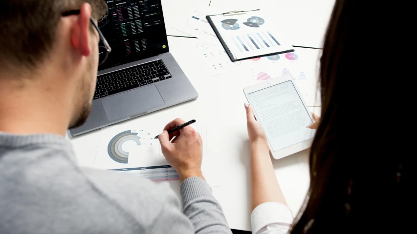 a couple of people sitting at a table with a laptop, analytical art, graphs, ecommerce photograph, thumbnail, firm