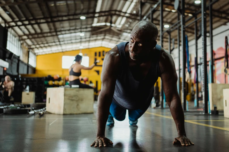 a man doing push ups in a gym, a photo, by Lee Loughridge, pexels contest winner, man is with black skin, aged 4 0, background image, avatar image