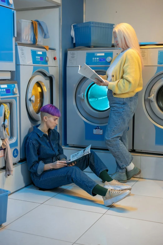 a couple of people sitting on the floor in front of a washing machine, inspired by Elsa Bleda, pexels contest winner, blue and purple scheme, inspect in inventory image, non binary future world, blonde women