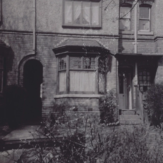 a black and white photo of a house, inspired by Lewis Henry Meakin, bay window, vintage footage, terraced, john longstaff