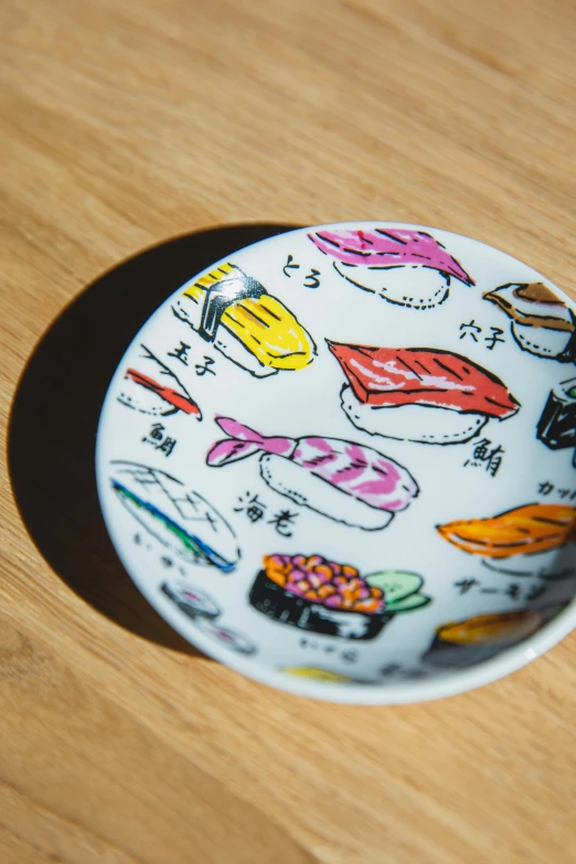 a plate sitting on top of a wooden table, a cartoon, inspired by Nishida Shun'ei, unsplash, ukiyo-e, teamlab, sushi, emma bridgewater and paperchase, miniature porcelain model