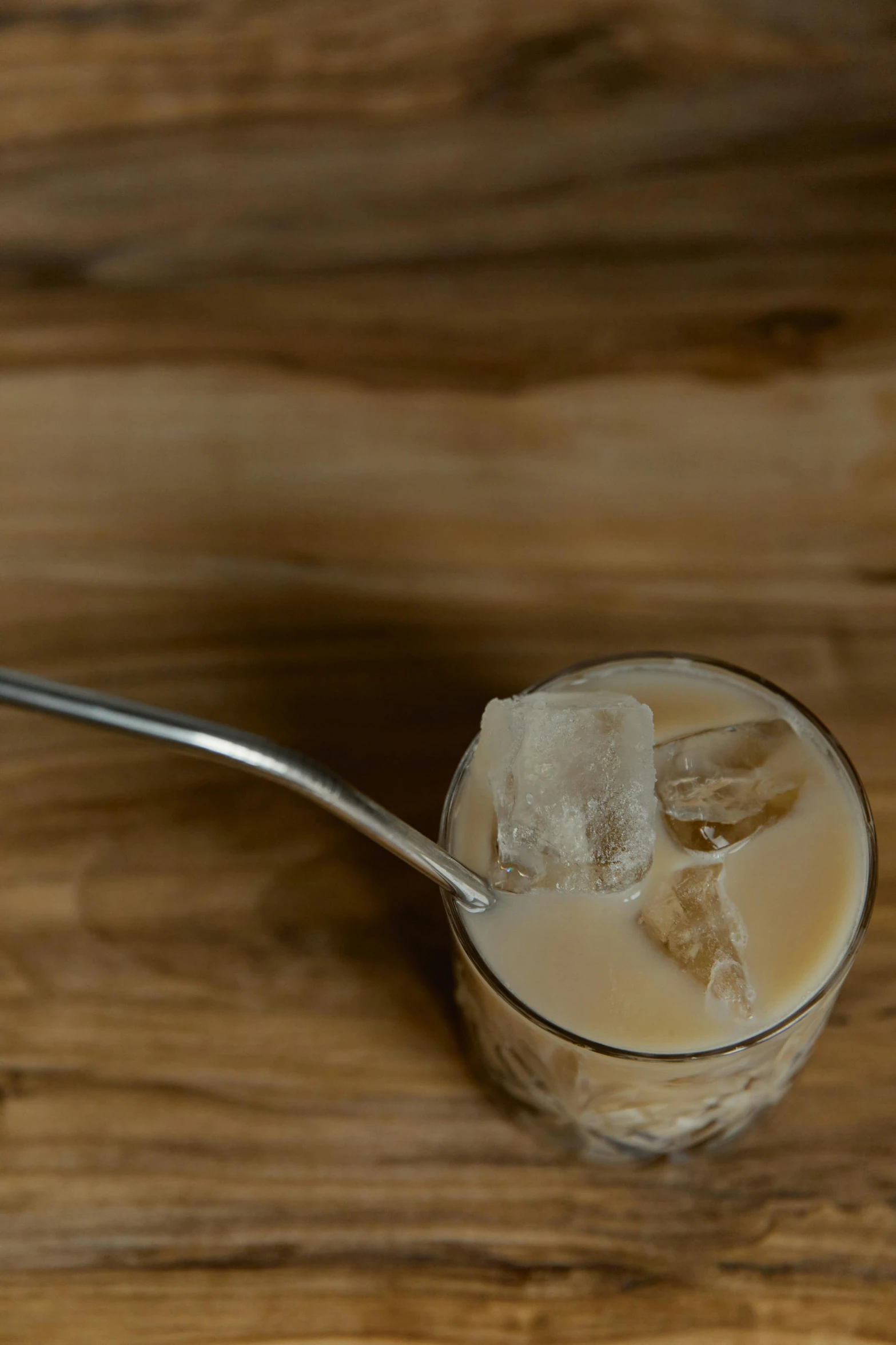 a spoon full of ice cream sitting on top of a wooden table, drinks bourbon, soymilk, jackstraws, c 12.0