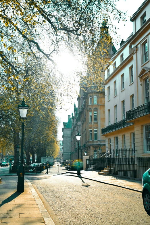 a green car parked on the side of a road, inspired by Albert Paris Gütersloh, neoclassicism, london architecture, square, amber, daylight