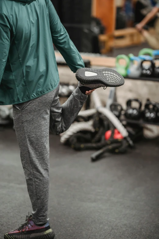 a woman holding a tennis racquet in a gym, by Jan Tengnagel, trending on unsplash, her foot sticking out, sauroform hybrid, grey, inspect in inventory image