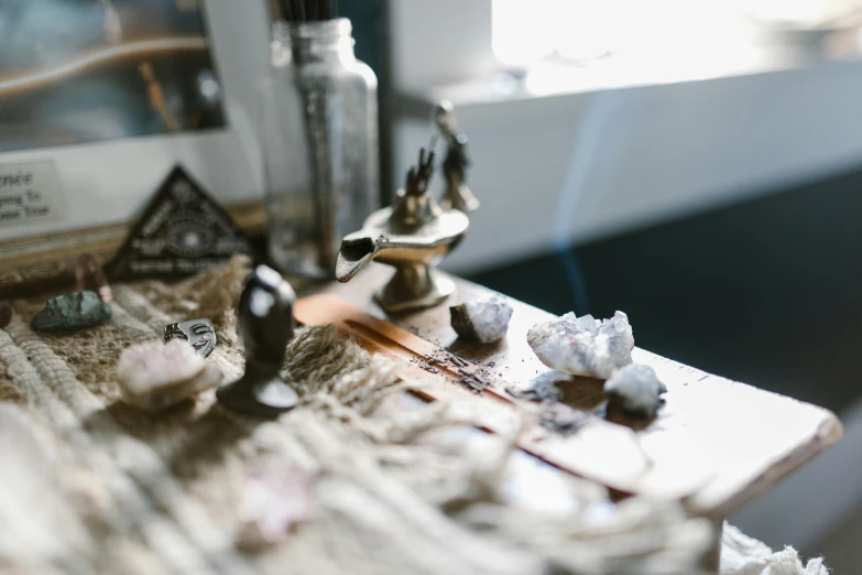 a close up of a sewing machine on a table, a still life, trending on pexels, beautiful crystals, incense, witchy, robed figures sat around a table