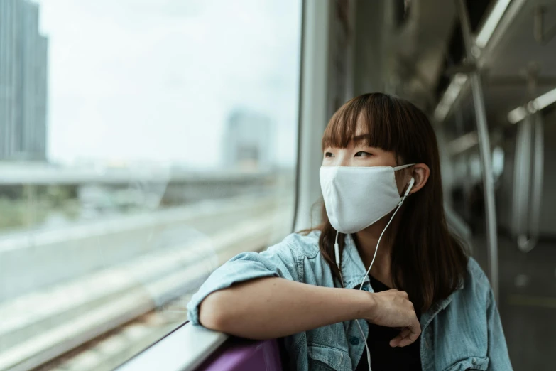 a woman wearing a face mask on a train, trending on pexels, avatar image, louise zhang, a person at a music festival, air pollution