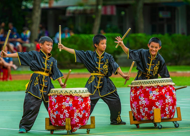 a group of men standing next to each other holding drums, inspired by Gong Kai, shutterstock, visual art, kids playing, square, taiwan, menacing!