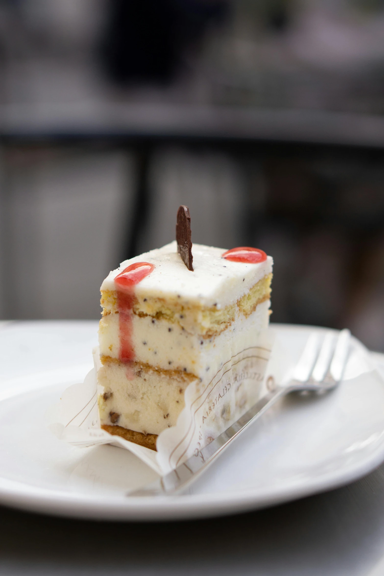 a piece of cake sitting on top of a white plate, san francisco, square, exterior shot, grey