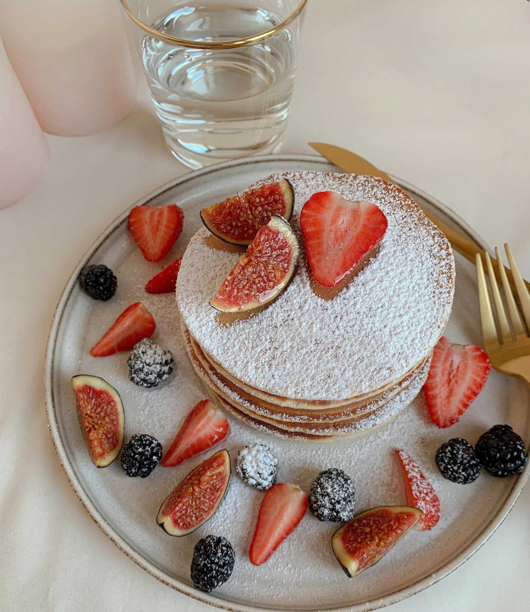 a plate topped with a stack of pancakes covered in powdered sugar, a stipple, by Eva Frankfurther, pexels, romanticism, 🎀 🍓 🧚, fruits, low quality photo, cake