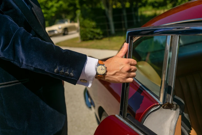 a man in a suit is opening the door of a red car, a picture, pexels contest winner, renaissance, gold watch, wearing a worn out brown suit, ( ( ( ( ( jaguar e - type car, thumbnail