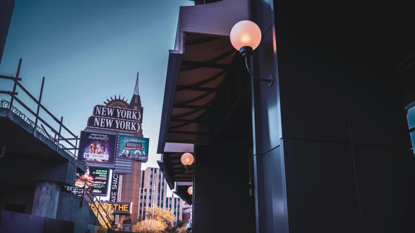 a street light sitting next to a tall building, sin city, marquee, in the evening