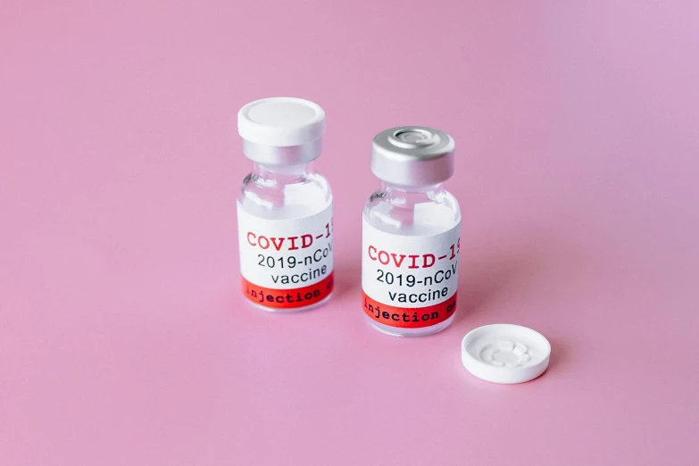 two vials sitting next to each other on a pink surface, shutterstock, covid, label, on a gray background, japanese collection product