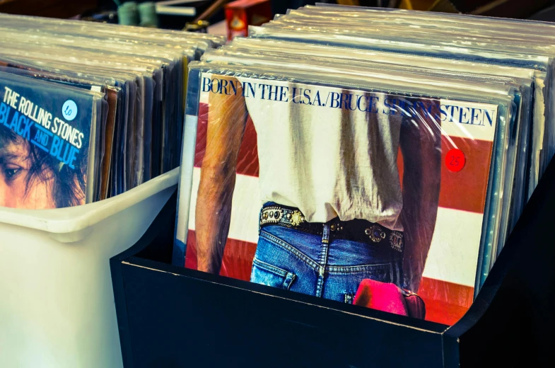 a bunch of records sitting on top of a table, bruce springsteen, vibrant colors americana, thumbnail, stood in a supermarket