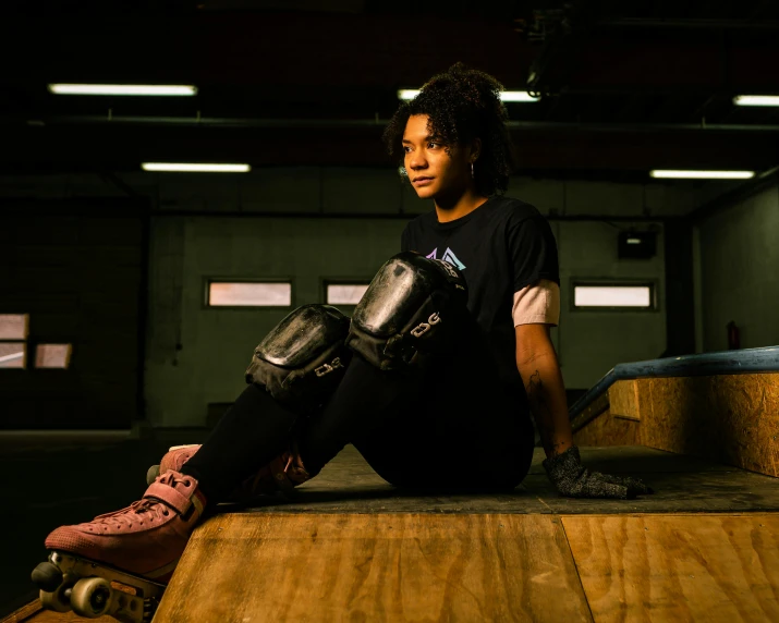 a woman sitting on top of a skateboard ramp, a portrait, unsplash, process art, wearing knee and elbow pads, in a warehouse, battle ready, portrait of vanessa morgan