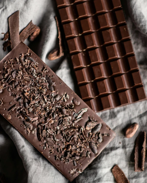 a piece of chocolate sitting on top of a table, by Julia Pishtar, slate, flatlay, promo image, bark