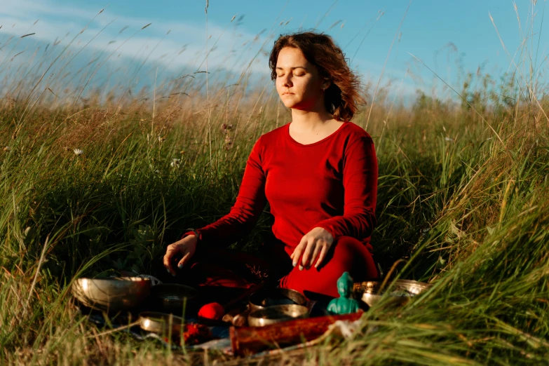 a woman sitting on top of a grass covered field, by Julia Pishtar, pexels contest winner, renaissance, in a red dish, hindu stages of meditation, ukrainian, 15081959 21121991 01012000 4k