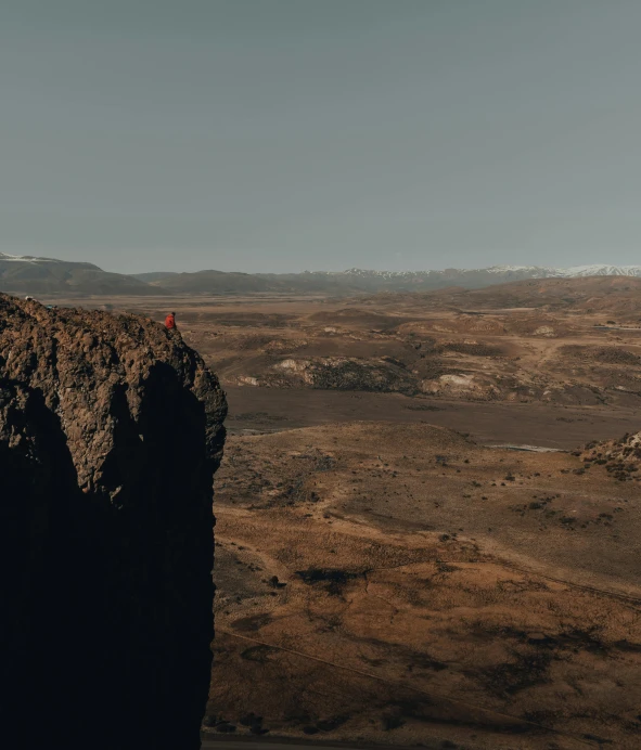 a person standing on top of a cliff, by Matthias Weischer, pexels contest winner, giant crater in distance, low quality photo, imbalanced mars. rugged, calmly conversing 8k