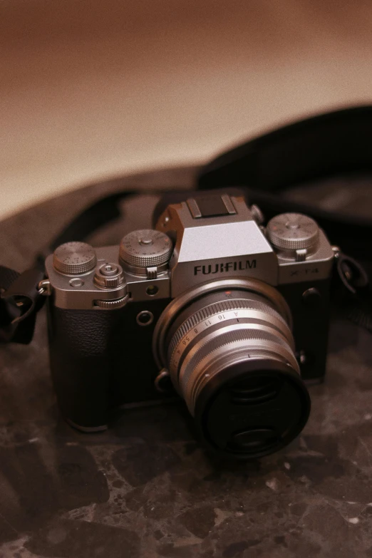 a close up of a camera on a table, fujifilm x-t3, low quality grainy, f / 1 1. 0, digital camera