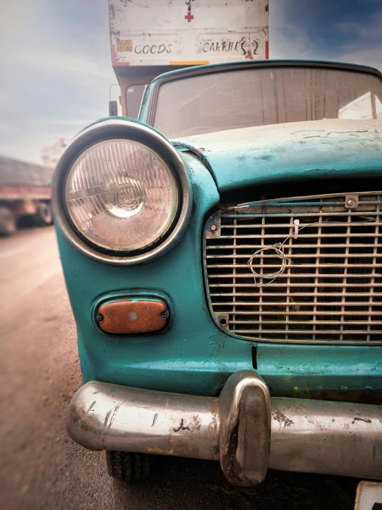 an old car is parked on the side of the road, by Sven Erixson, pexels contest winner, photorealism, turquoise blue face, square, hazy, rugged face