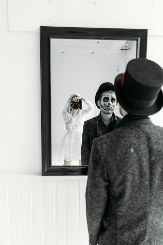 a man that is standing in front of a mirror, by Lucia Peka, pexels contest winner, ska skeleton and girlfriend, posing in disguise among humans, wedding photo, white face