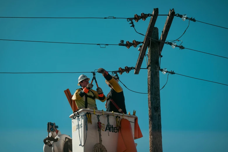 a couple of men standing on top of a power pole, utility, promo image, people at work, brown