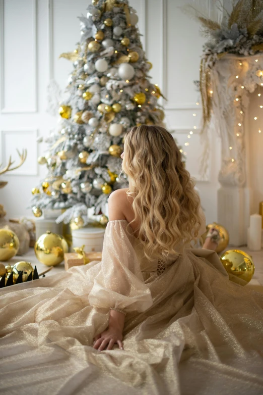 a woman sitting in front of a christmas tree, shutterstock, baroque, flowy yellow golden hair, long luxurious light blond hair, gif, lifestyle