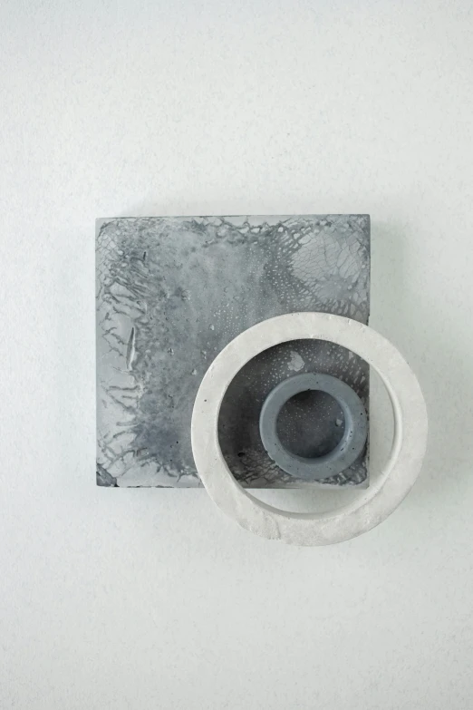 a white toilet sitting next to a toilet paper dispenser, an abstract sculpture, inspired by Jakob Emanuel Handmann, concrete art, view from above, grey colours, shaped like torus ring, singularity sculpted �ー etsy