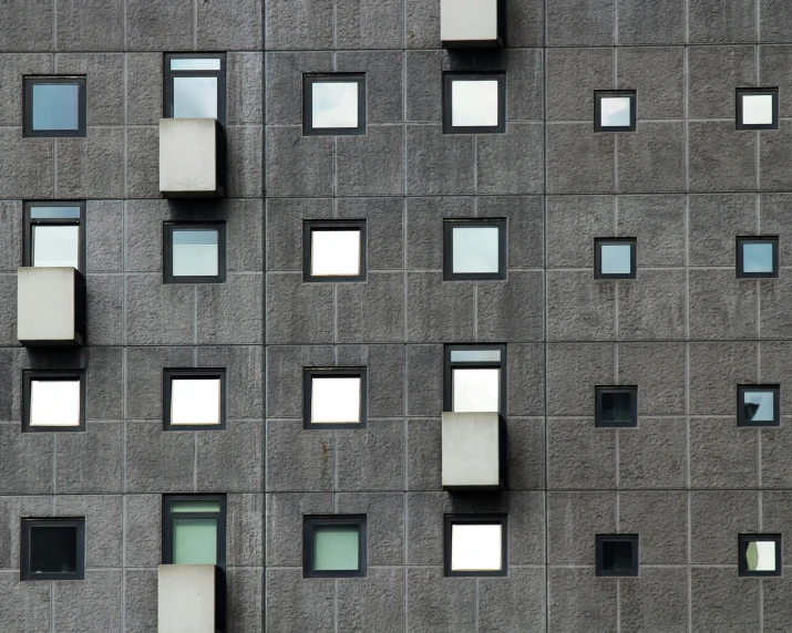 a very tall building with lots of windows, inspired by David Chipperfield, unsplash, brutalism, small windows, ignant, steel window mullions, various sizes