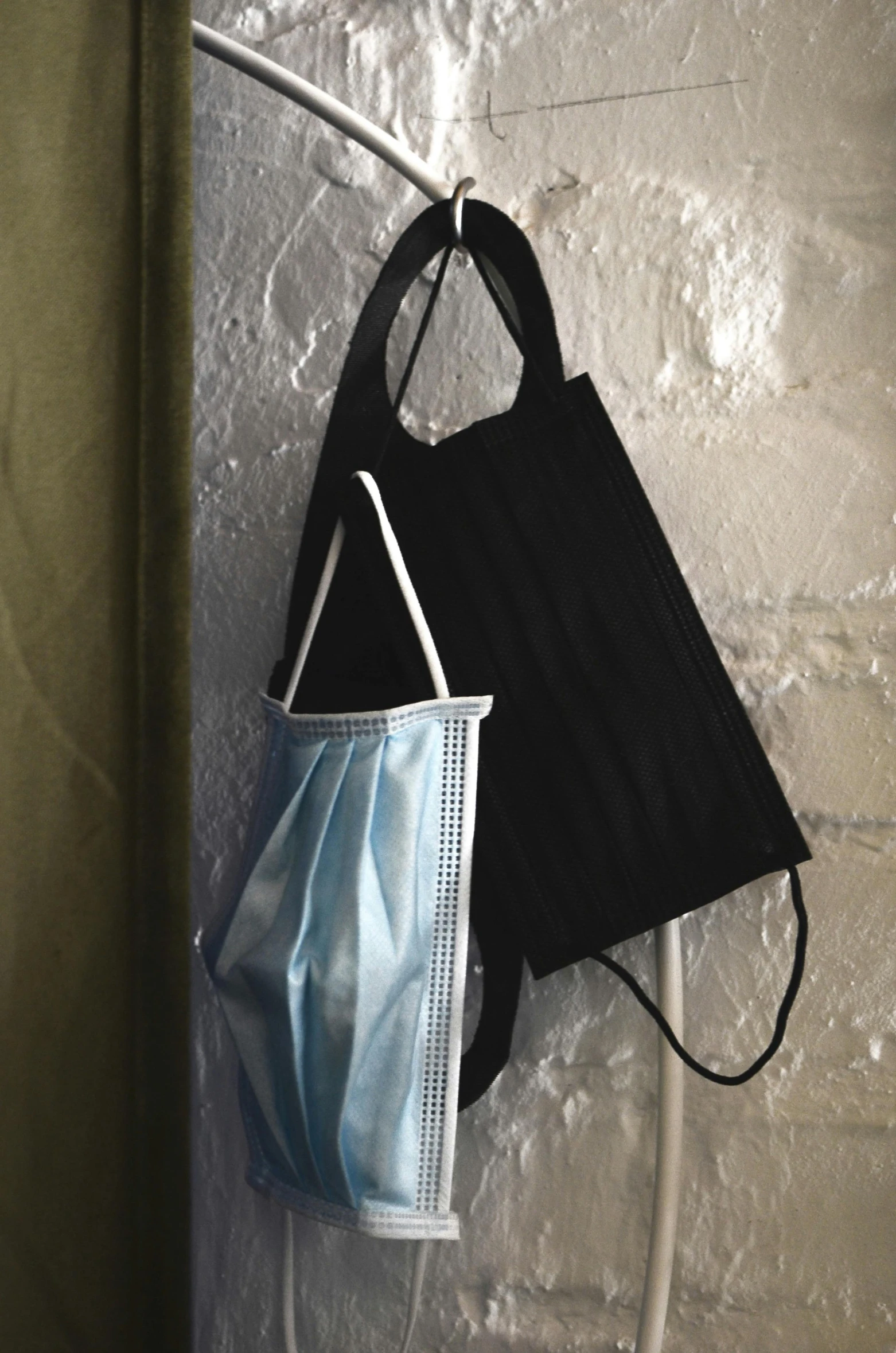 a pair of face masks hanging on a wall, black and blue, bag, thumbnail, uncropped