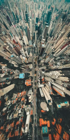 an aerial view of a city with lots of tall buildings, by Patrick Ching, pexels contest winner, hyperrealism, instagram post, 8k vertical wallpaper, viewed from earth, opening shot