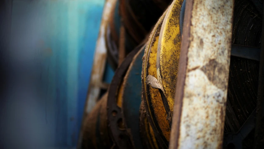 a couple of spools sitting next to each other, inspired by Max Ernst, unsplash, mining scrap metal, yellow and blue, closeup photograph, plows