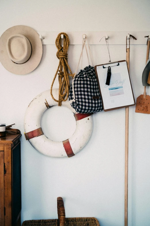 a bunch of hats hanging on a wall, a picture, by Jessie Algie, trending on unsplash, boat with lamp, white broom closet, inspect in inventory image, hook as ring