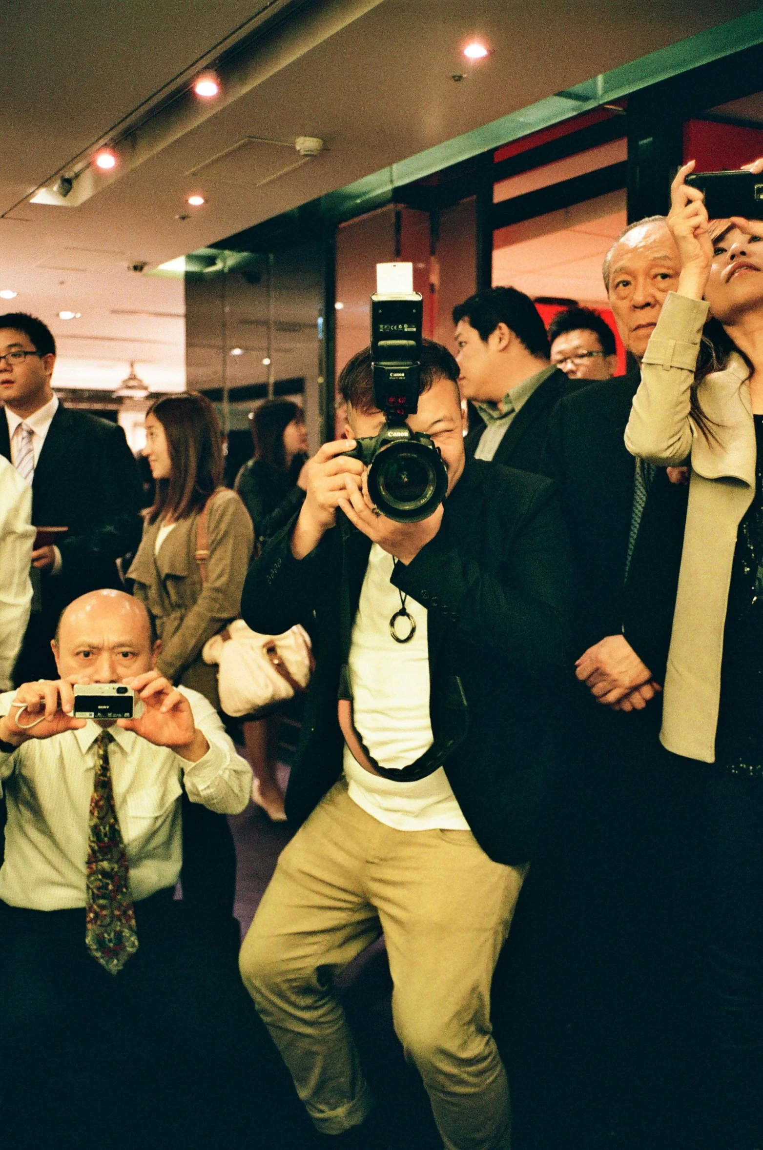 a group of people taking pictures with their cell phones, a picture, by David Diao, paul lung, standing elegantly, taken on a 1990s camera, shocked