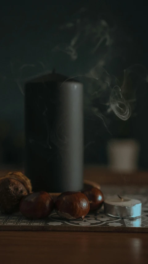 a cup of coffee and some nuts on a table, a still life, by Andries Stock, pexels contest winner, purism, witch burning, smoke columns, dark grey, candle volumetric