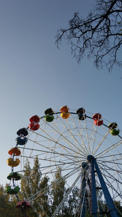 a ferris wheel in a park with trees in the background, by Niko Henrichon, unsplash, hurufiyya, low quality photo, sunny sky, фото девушка курит, colored photo