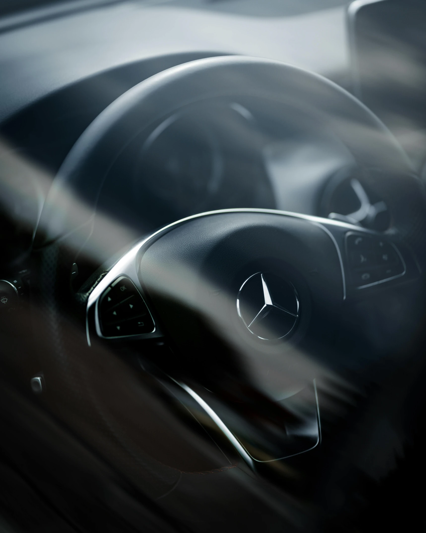 a close up of a steering wheel in a car, by Adam Marczyński, pexels contest winner, photorealism, mercedes, on black paper, blurry image, 2 0 % pearlescent detailing