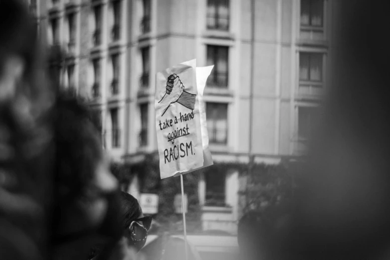a black and white photo of a protest sign, by Emma Andijewska, unsplash, excessivism, brown, cartoonish, blame, left profile