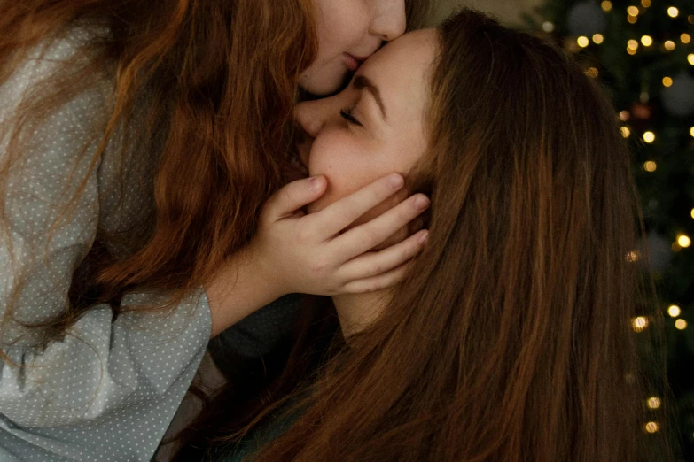 two girls kissing each other in front of a christmas tree, by Julia Pishtar, trending on pexels, long ginger hair, movie still 8 k, in the bedroom at a sleepover, girl with dark brown hair