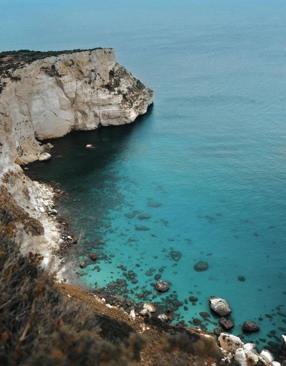 a large body of water next to a cliff, pexels contest winner, cyprus, lgbtq, blue! and white colors, black