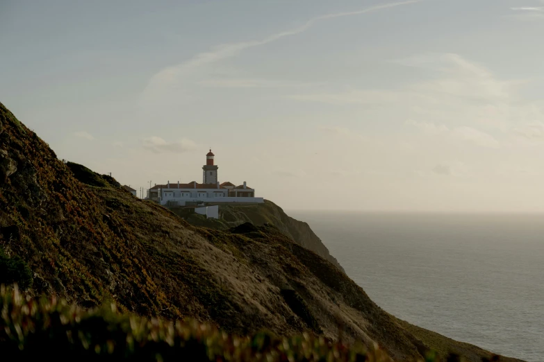 a lighthouse sitting on top of a cliff next to the ocean, lisbon, fan favorite, farming, medium height