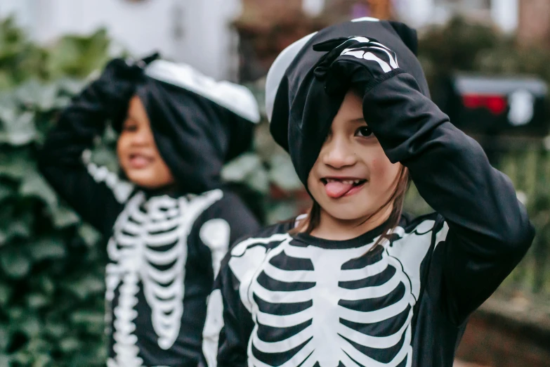 two young children dressed up in halloween costumes, by Helen Stevenson, unsplash, visual art, cute skeleton, te pae, zoomed in, black