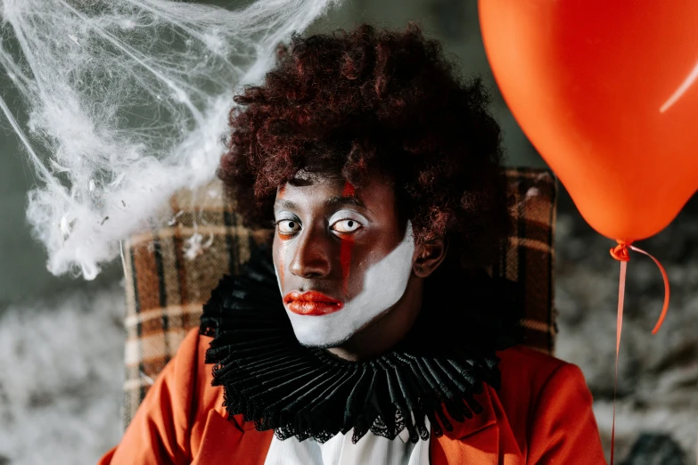 a clown sitting in a chair with a red balloon, a portrait, trending on pexels, renaissance, with brown skin, trick or treat, red contact lenses, fluffy orange skin