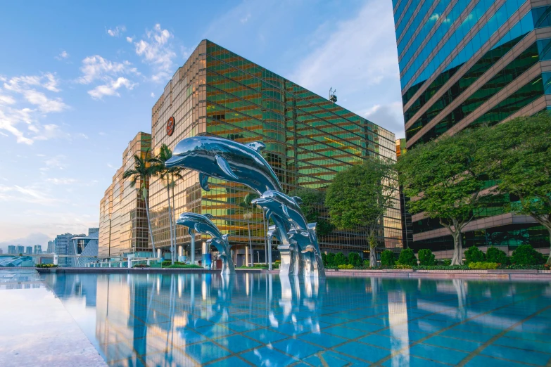 two dolphins jumping out of the water in front of a building, an abstract sculpture, inspired by Jeff Koons, pexels contest winner, highrise business district, in marijuanas gardens, reflections in copper, landscape architecture photo