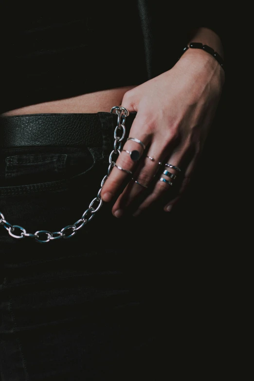 a woman with a chain around her waist, inspired by Elsa Bleda, trending on pexels, metal gauntlet, hip hop aesthetic, ring lit, gradient black to silver