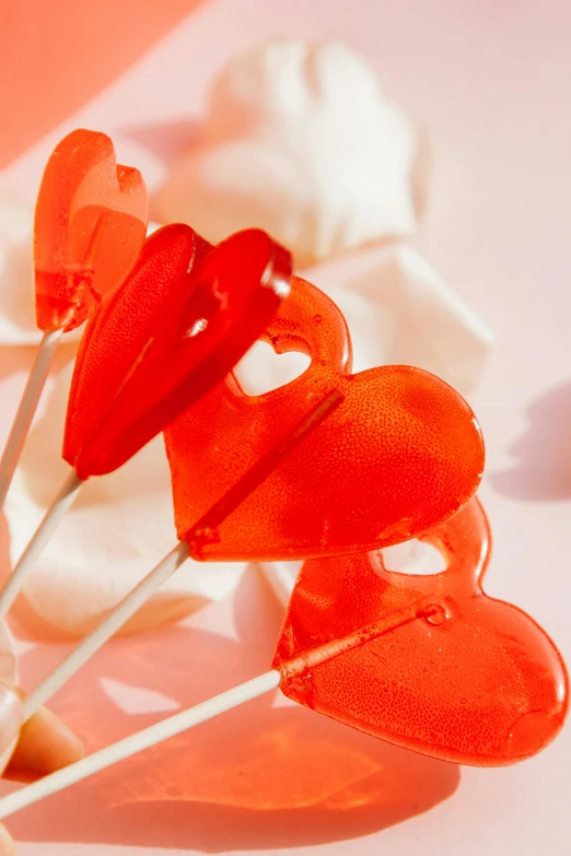 a bunch of heart shaped lollipops on a stick, by Julia Pishtar, light red and orange mood, gummy candies, profile image, made of candy