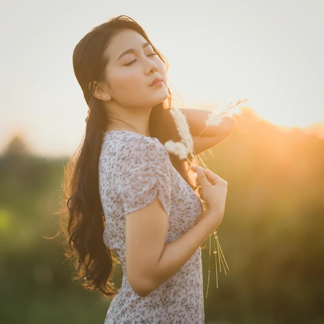 a woman standing in a field with a flower in her hand, inspired by Xie Sun, pexels contest winner, gorgeous young korean woman, girl with plaits, softly backlit, 15081959 21121991 01012000 4k