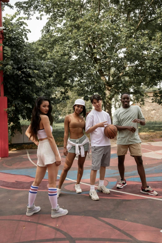 a group of people standing on top of a basketball court, an album cover, trending on pexels, boy shorts, actors, a park, diverse costumes