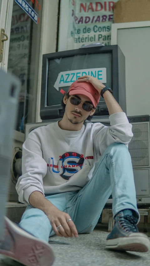 a man sitting on the ground in front of a tv, a colorized photo, inspired by Aleksander Gine, unsplash contest winner, aestheticism, wearing sunglasses and a cap, sitting on a store shelf, pastel clothing, sayem reza